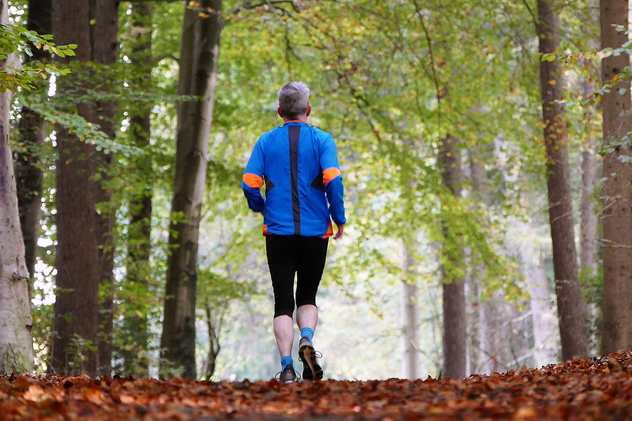 Homme courant en forêt, symbole de la reprise d'activité physique pour prévenir les douleurs lombaires